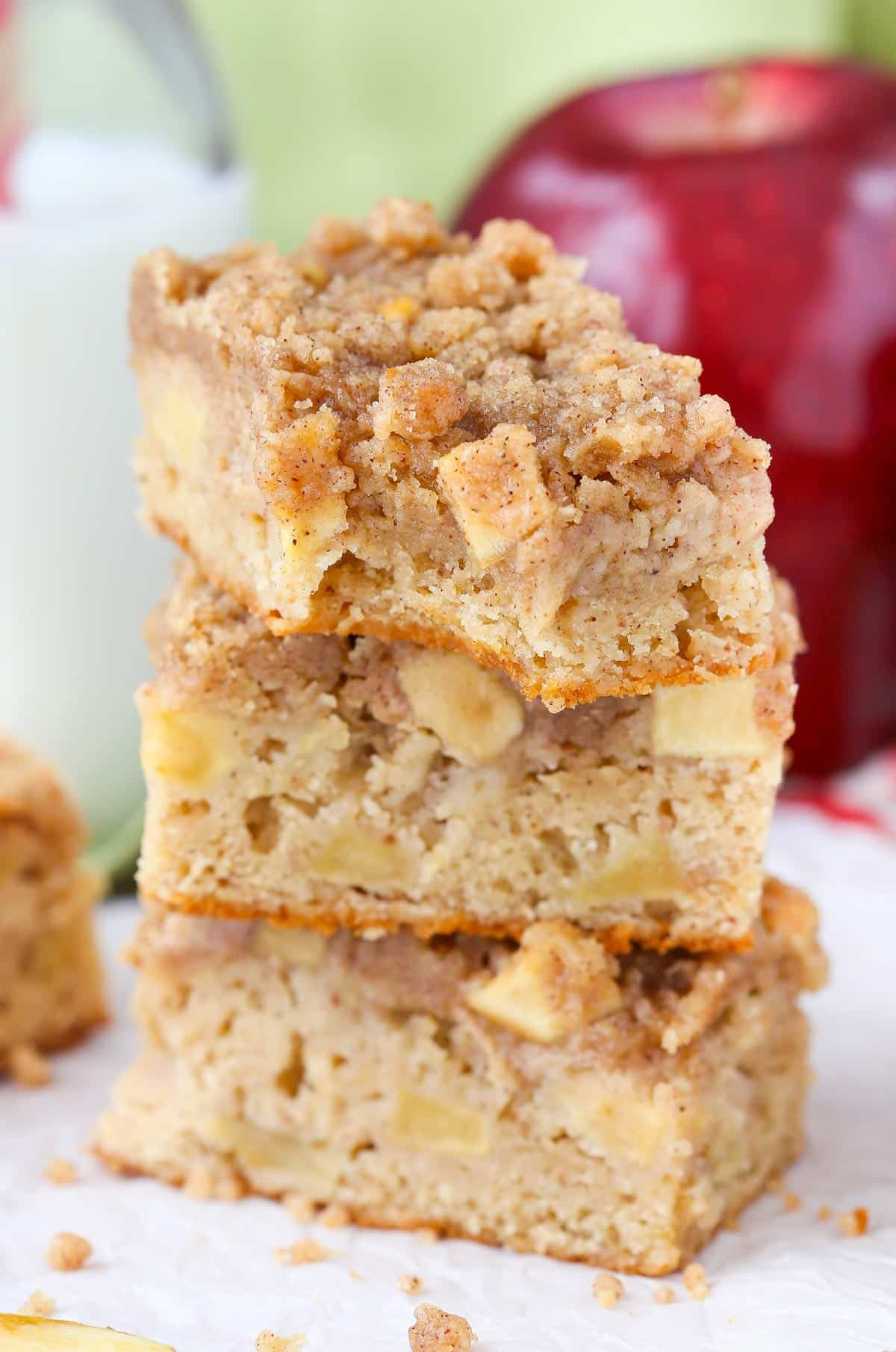 Three stacked apple streusel bars with a bite taken out of the top bar.