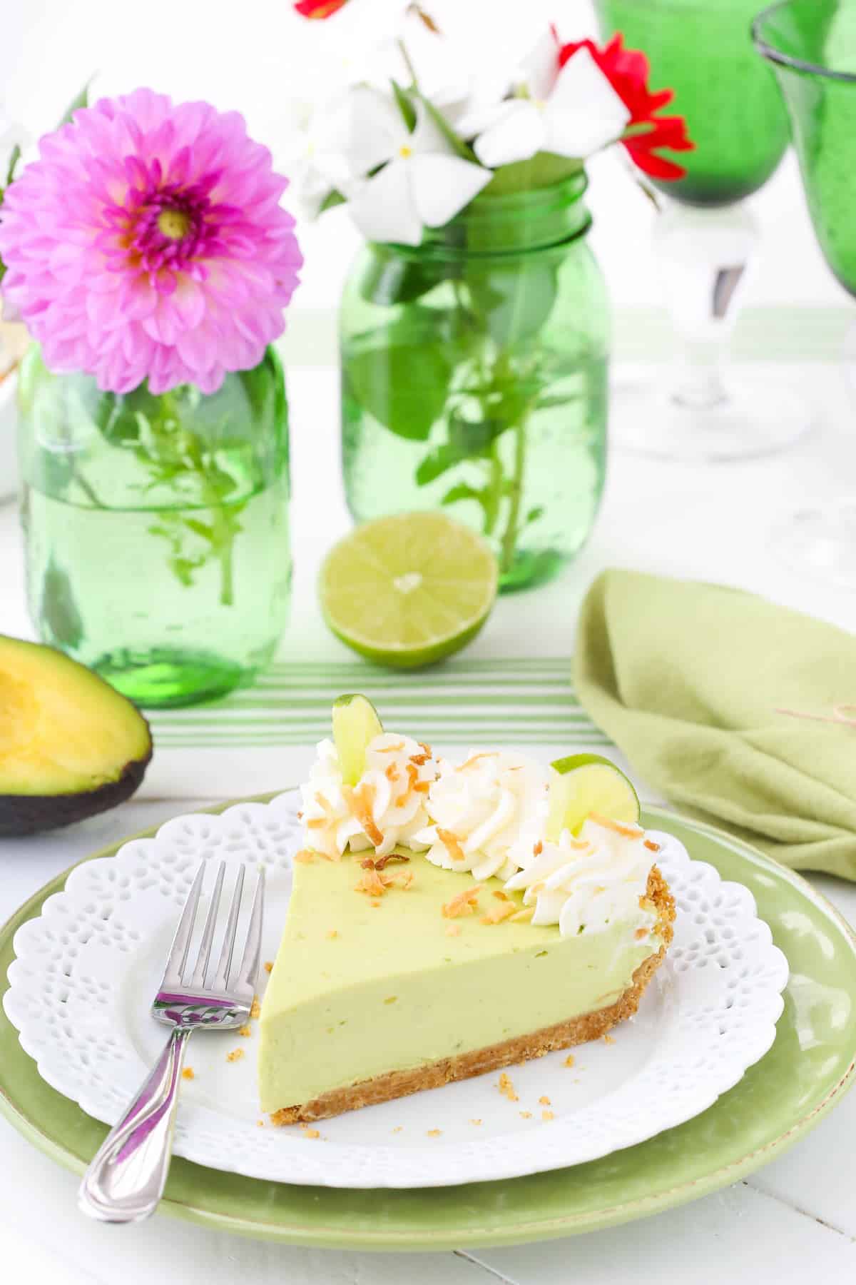 A slice of avocado key lime pie on a small white plate.