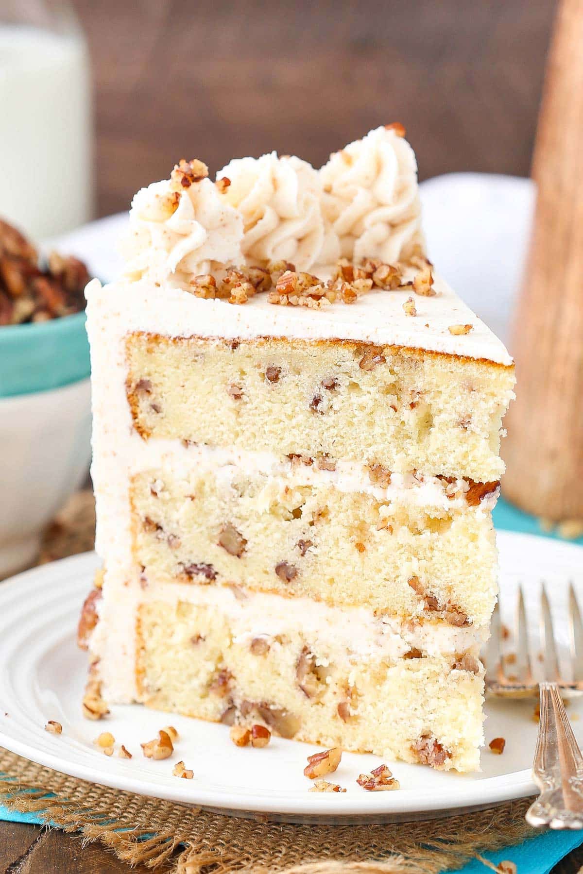 Close up of a slice of browned butter pecan layer cake on a plate.