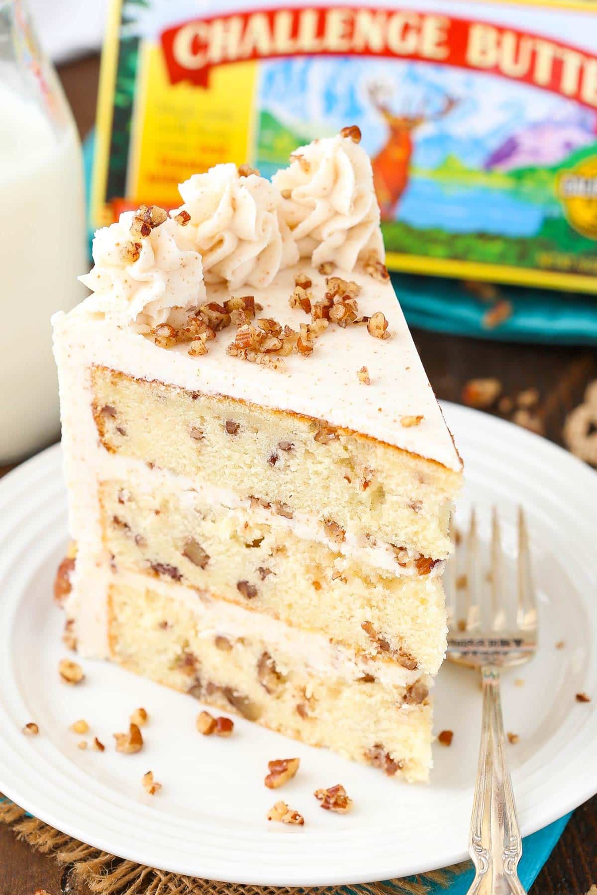 Top view of a slice of browned butter pecan layer cake on a white plate.
