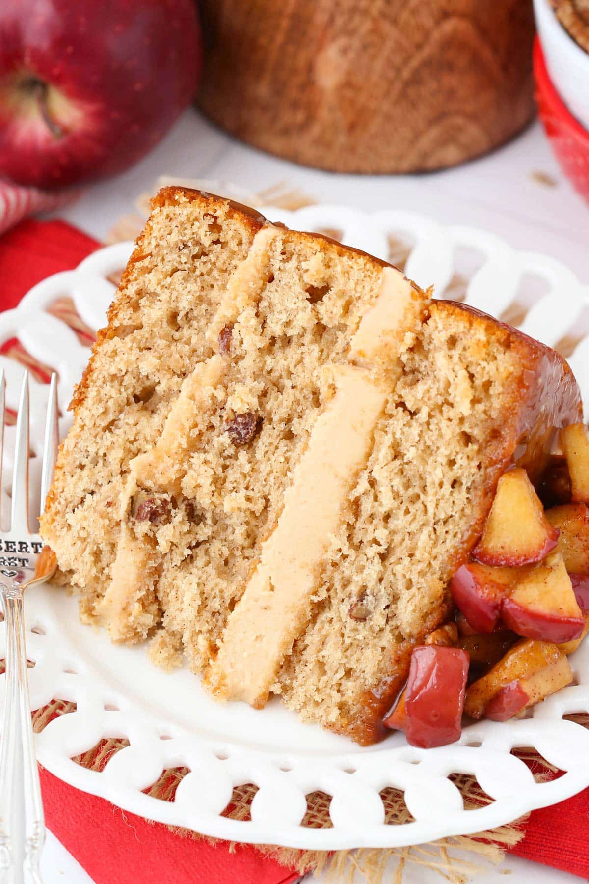Close up of a slice of caramel apple pecan layer cake on a white plate.