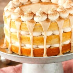 Close up of a cinnamon roll layer cake on a silver stand.
