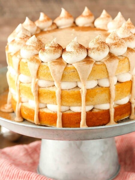 Close up of a cinnamon roll layer cake on a silver stand.