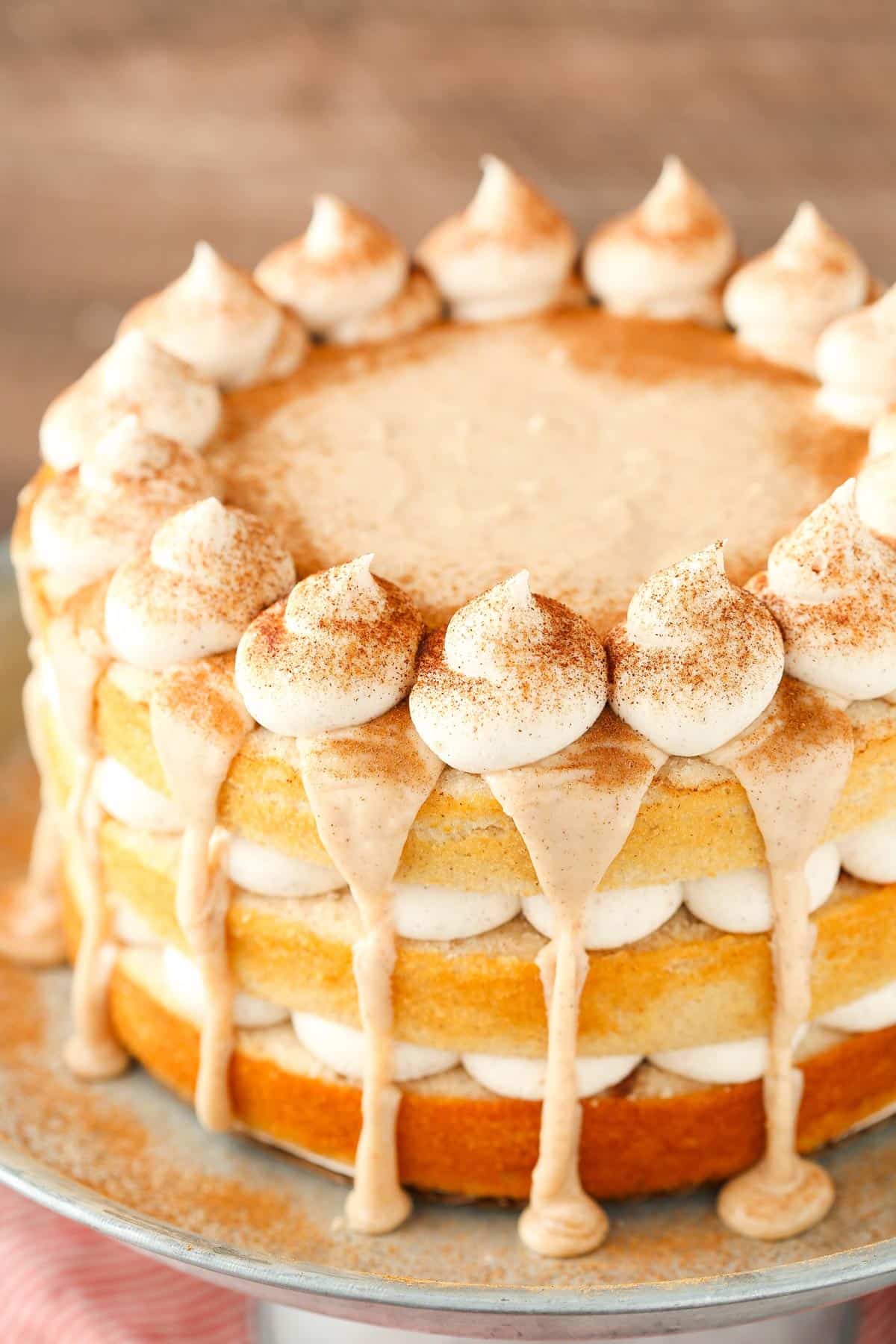 Close up of the top of a cinnamon roll layer cake on a silver stand.