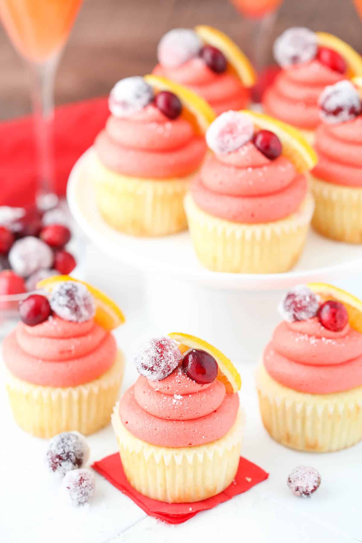 Top view of a few cranberry mimosa cupcakes with more cupcakes in the background.