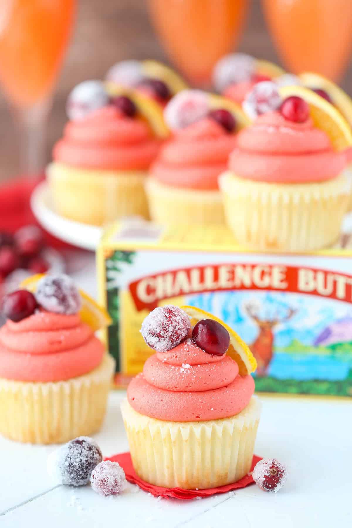 Close up of a cranberry mimosa cupcake with a box of butter in the background.