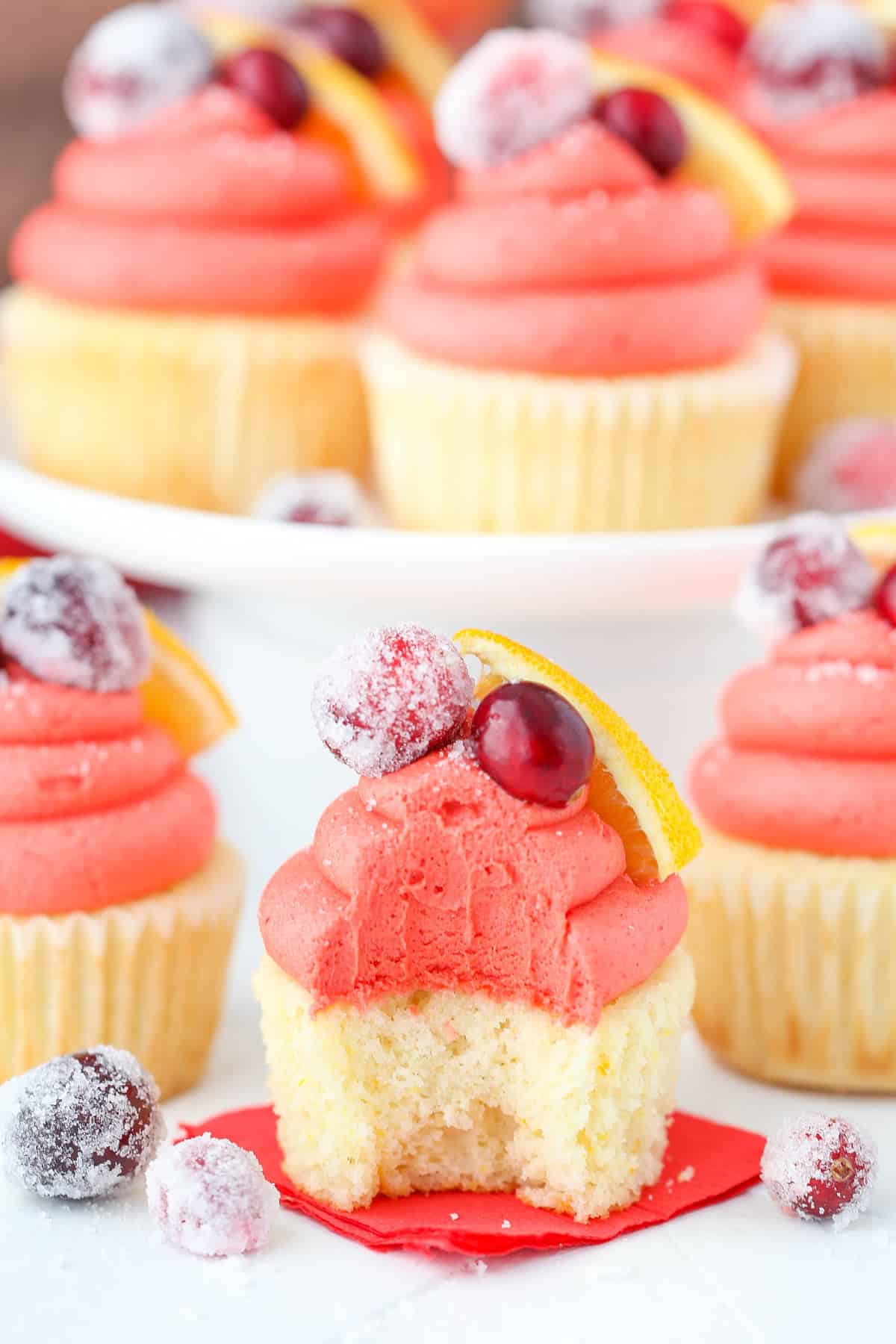 Close up of a cranberry mimosa cupcake with a bite taken out of it.