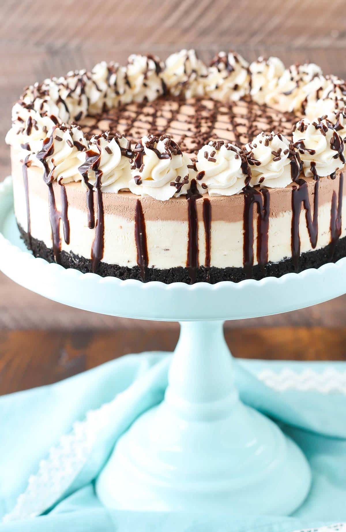 A frozen Irish cream mousse cake on a light blue cake stand.