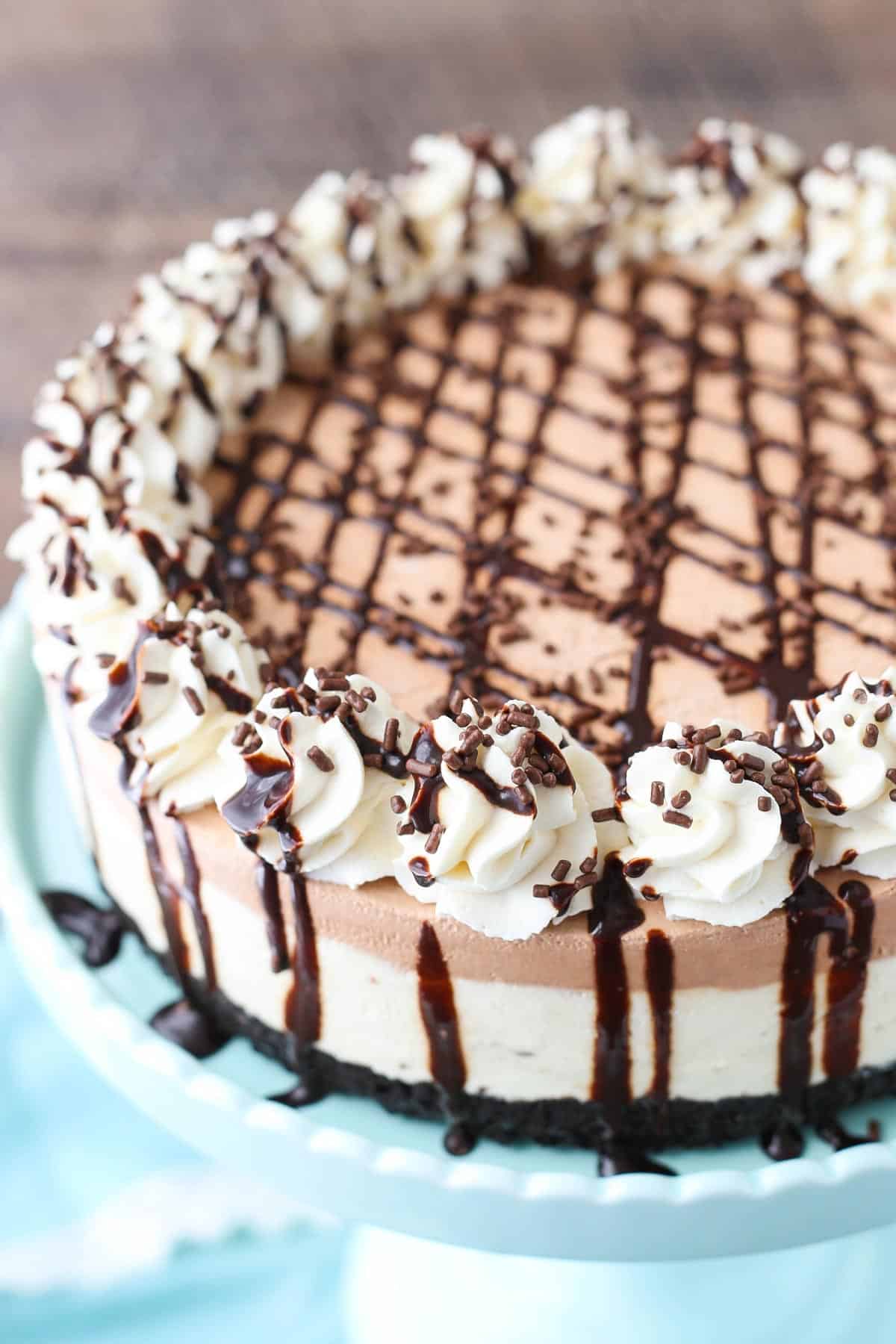 A frozen Irish cream mousse cake on a light blue cake stand.