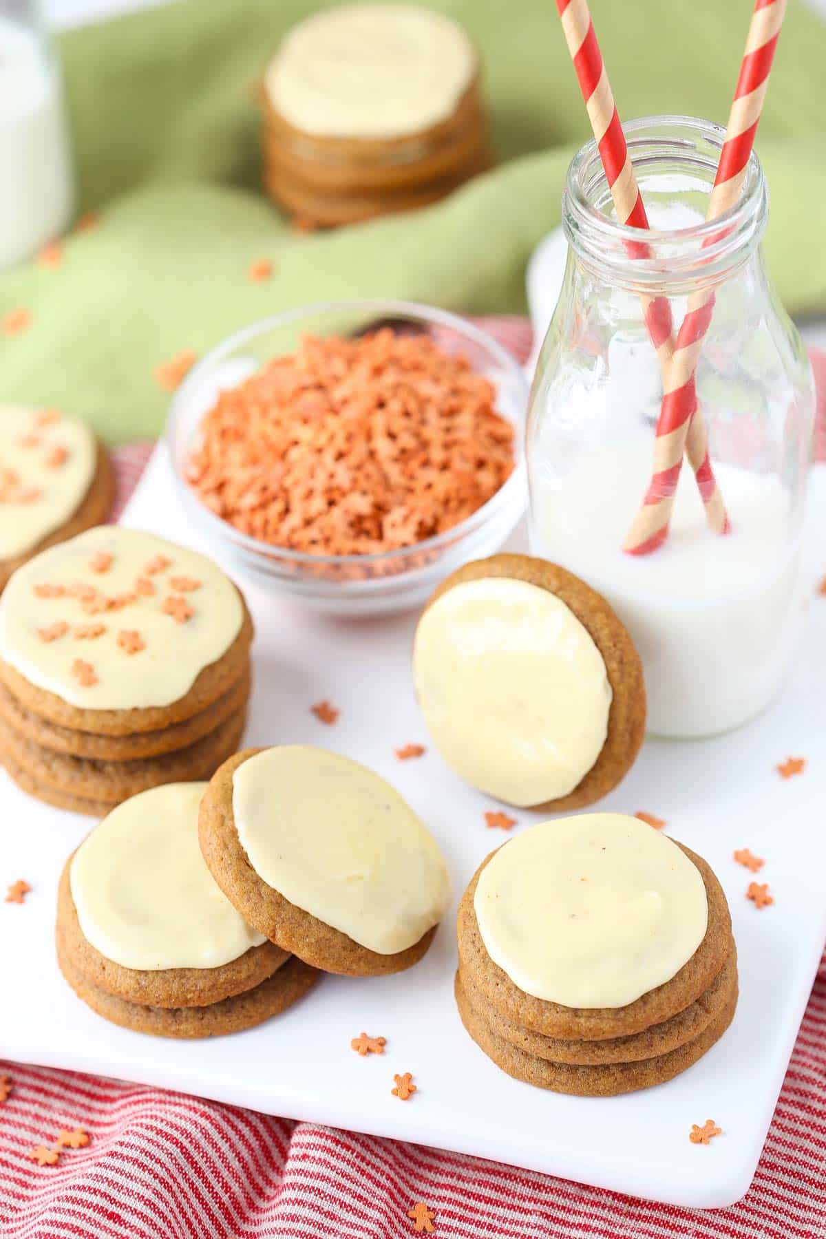 A few stacks of gingerbread cookies with eggnog icing on a white tray.