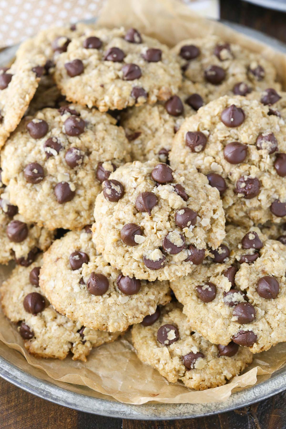 A pile of gluten and dairy free oatmeal chocolate chip cookies on a silver tray.