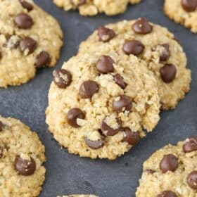 Close up of two slightly overlapped gluten and dairy free oatmeal chocolate chip cookies.