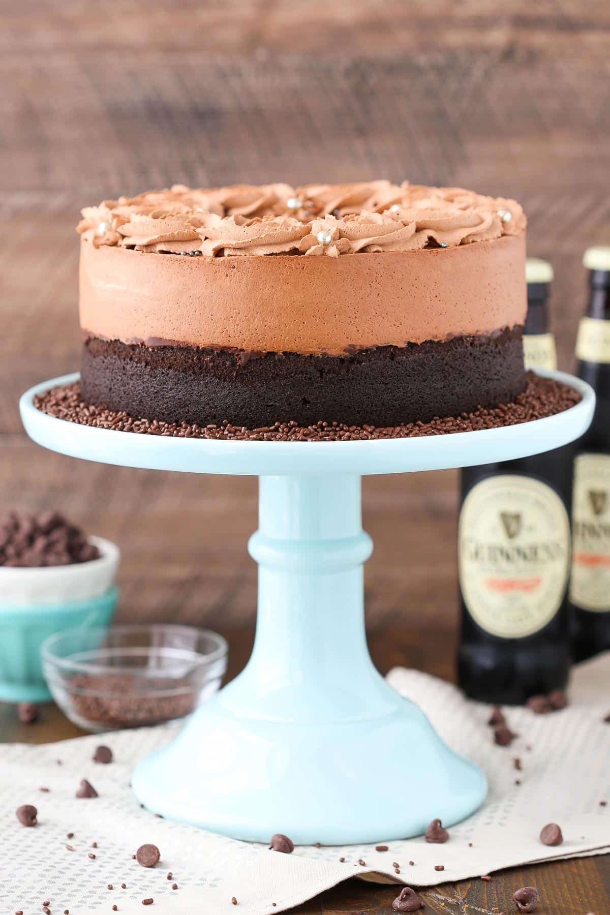 A Guinness chocolate mousse cake on a tall blue cake stand.