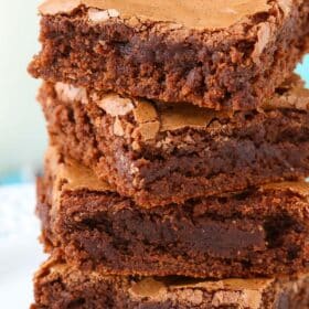 Close up of a stack of 4 fudgy brownies.