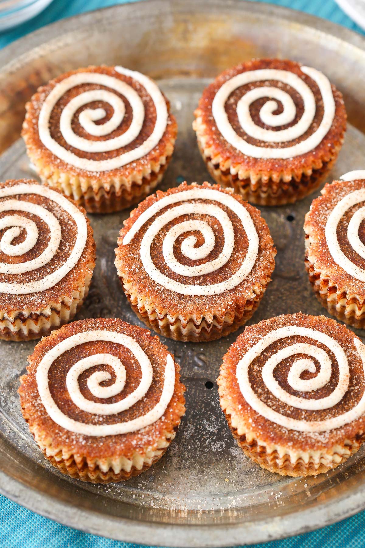 Top view of a silver tray of mini cinnamon roll cheesecakes.
