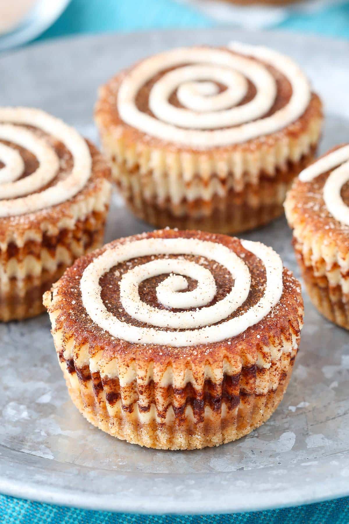 Close up of a mini cinnamon roll cheesecakes on a silver plate.