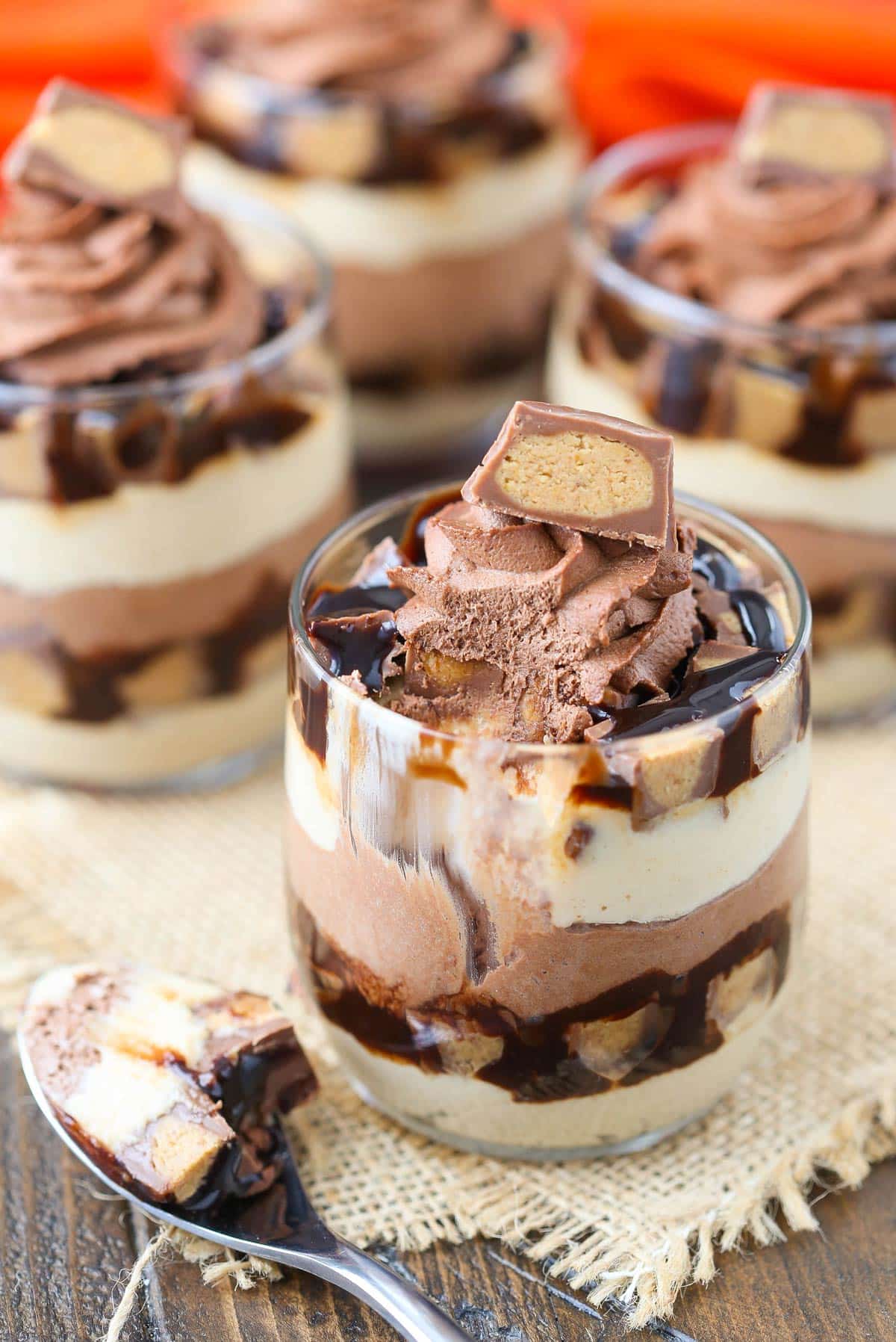 Close up of a mini Reeses chocolate peanut butter cheesecake trifle with a bite removed on a spoon.