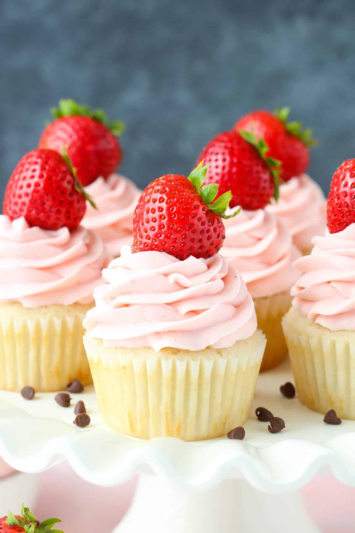 Close up of neapolitan cupcakes on a white cake stand.