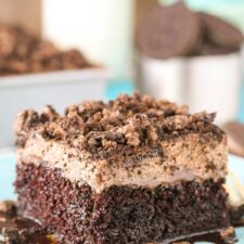 A slice of Oreo Chocolate Poke Cake on a blue plate.