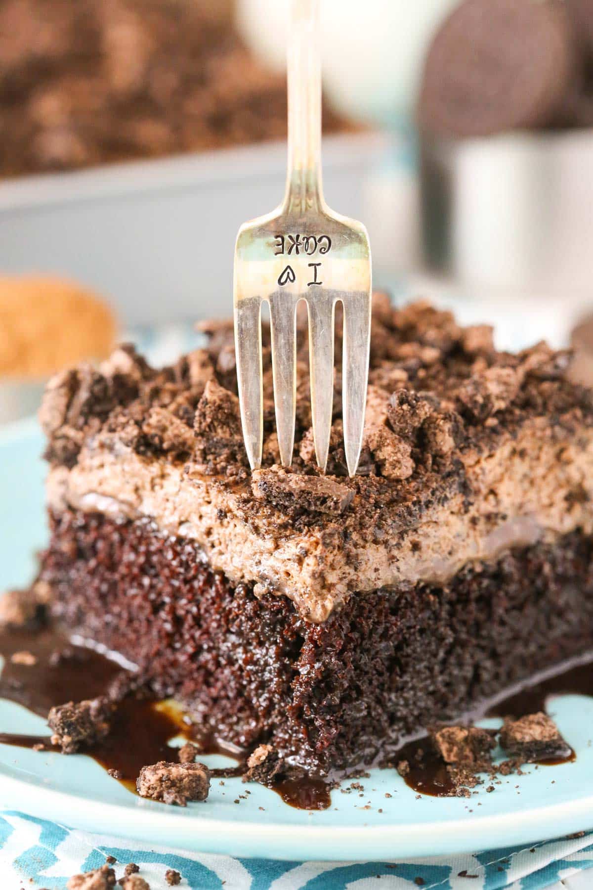 A slice of Oreo Chocolate Poke Cake with a fork in it.