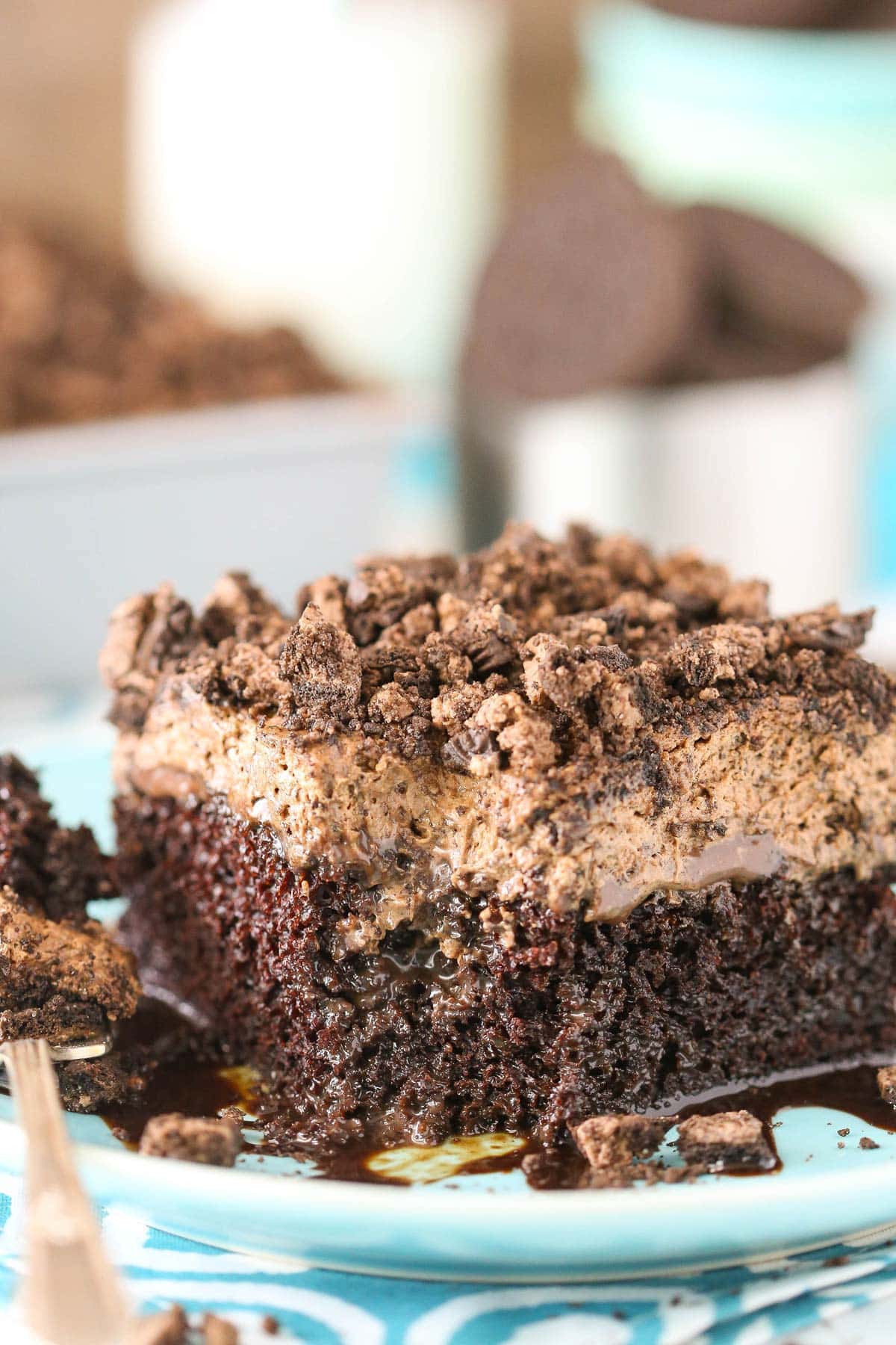 A slice of Oreo Chocolate Poke Cake with a bite removed.