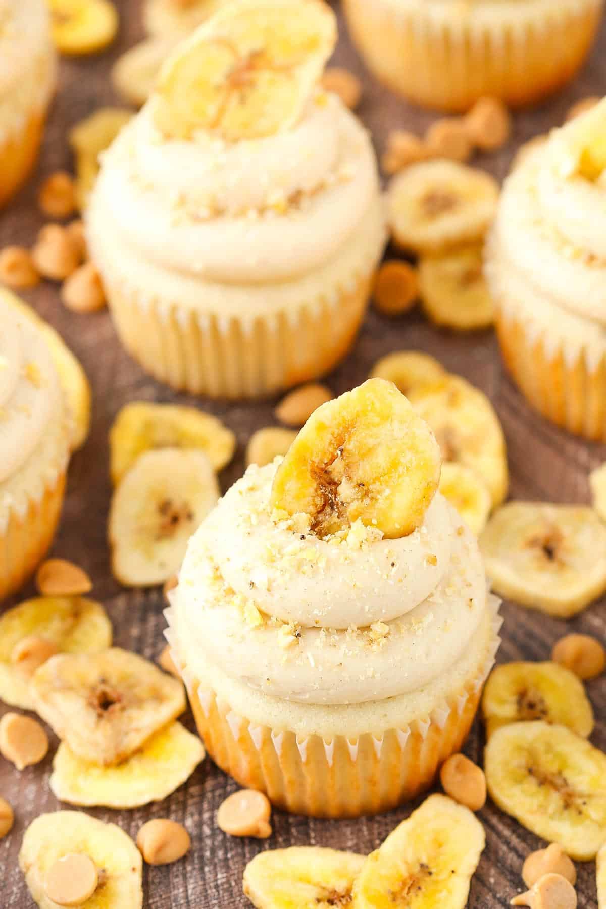 Top view of peanut butter banana cupcakes surrounded by banana chips and peanut butter chips.