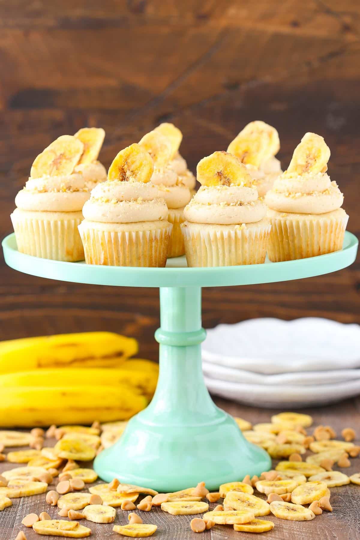 A light teal cake stand topped with peanut butter banana cupcakes.