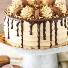 Close up of a peanut butter chocolate layer cake on a silver cake stand.