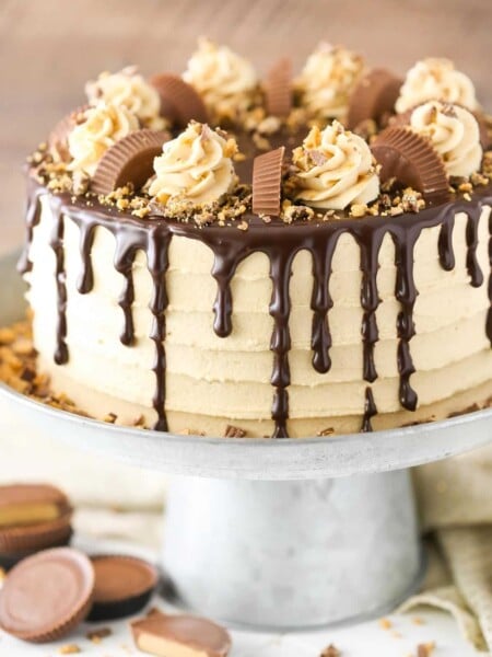 Close up of a peanut butter chocolate layer cake on a silver cake stand.
