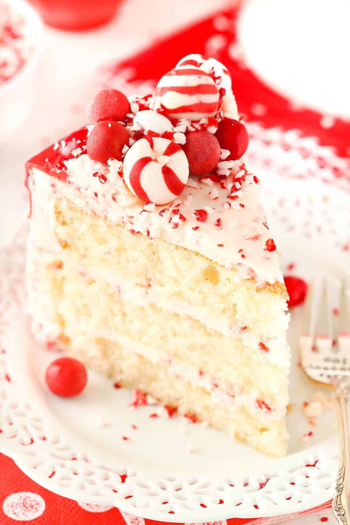 A slice of peppermint chip layer cake on a small white plate.