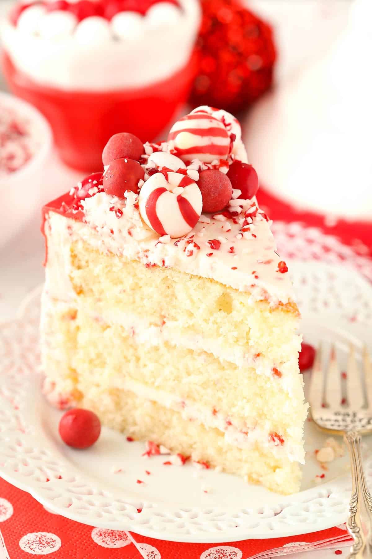 A slice of peppermint chip layer cake on a small white plate.