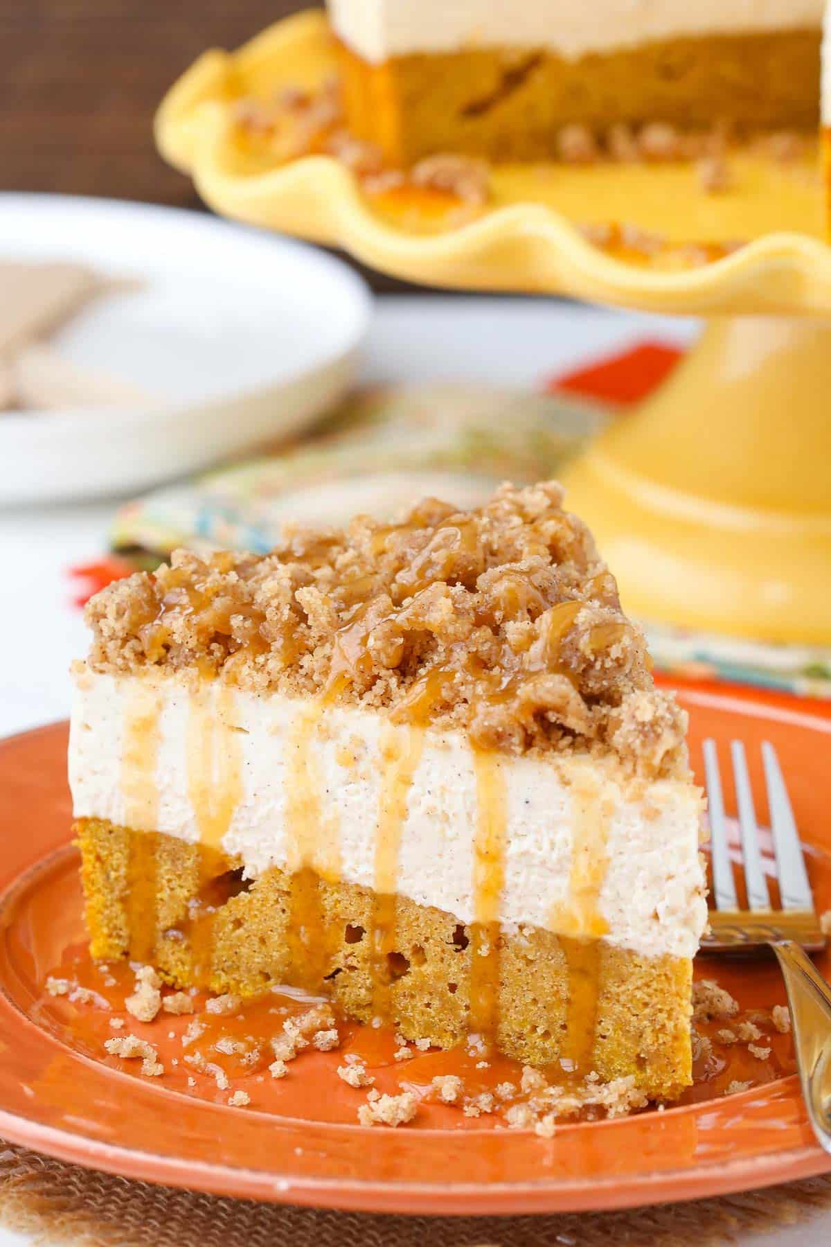 Close up of a slice of caramel pumpkin spice blondie streusel cheesecake on an orange plate.