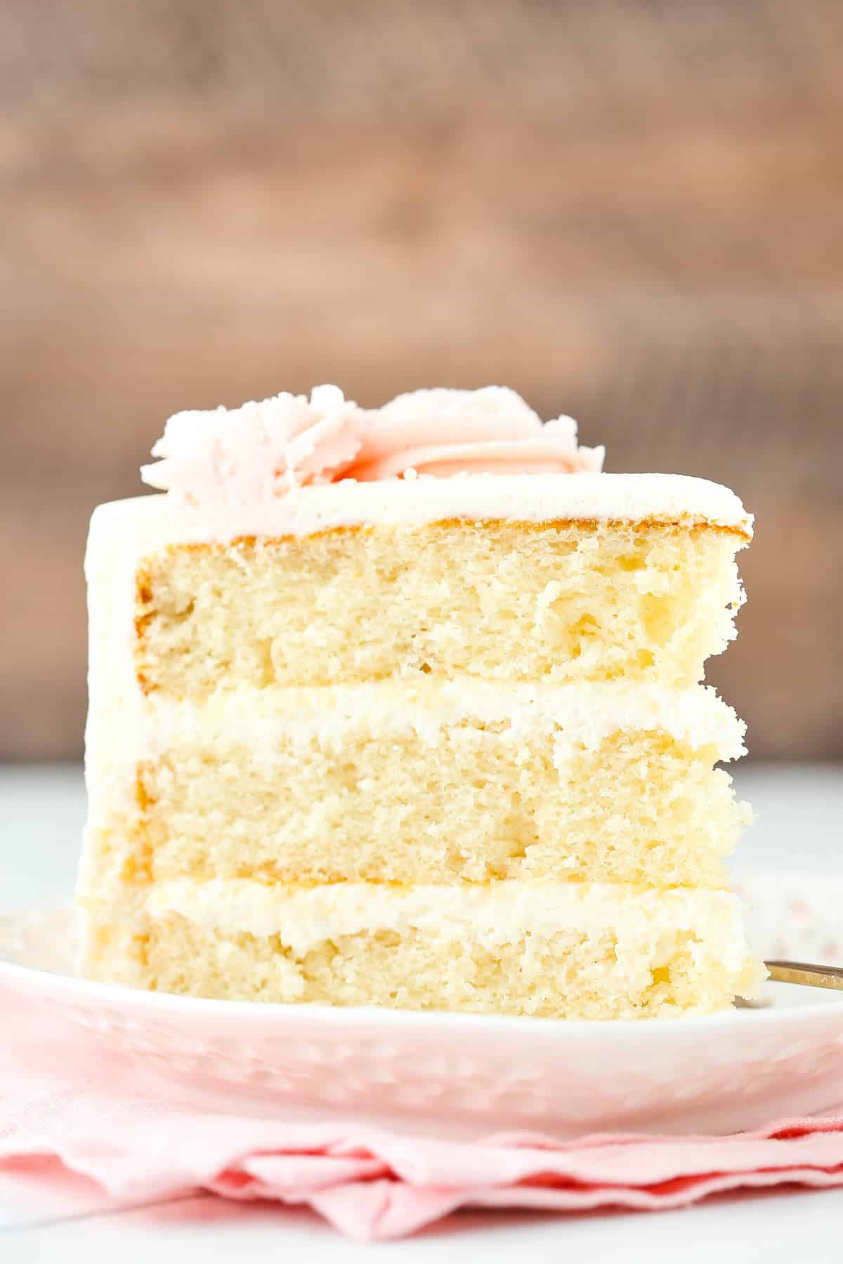 Side view of a slice of rose water vanilla layer cake.