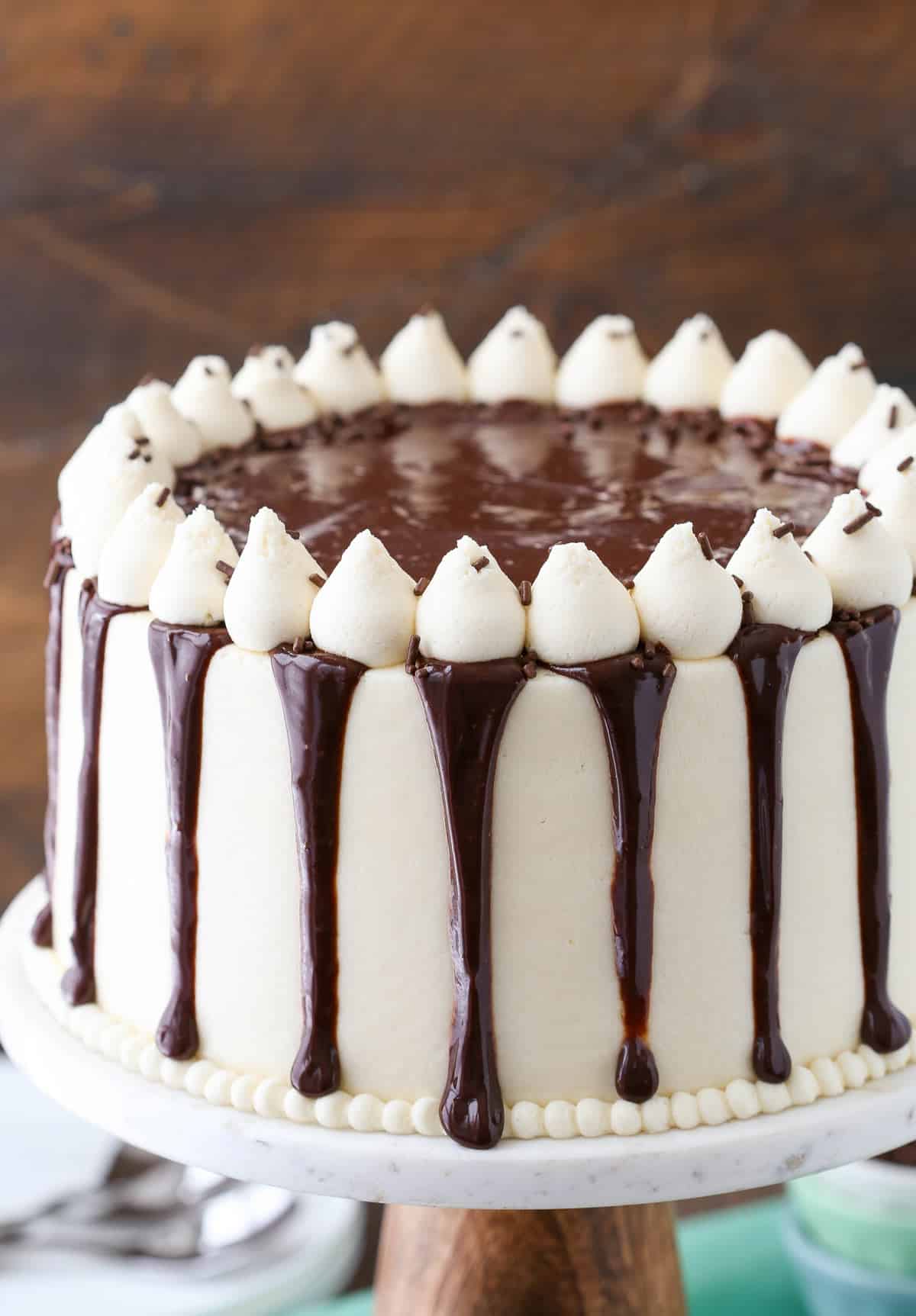 Close up of a Baileys chocolate cake on a marble cake stand.