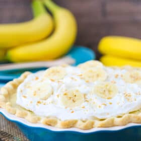 Side view of a banana cream pie in a blue pie pan.