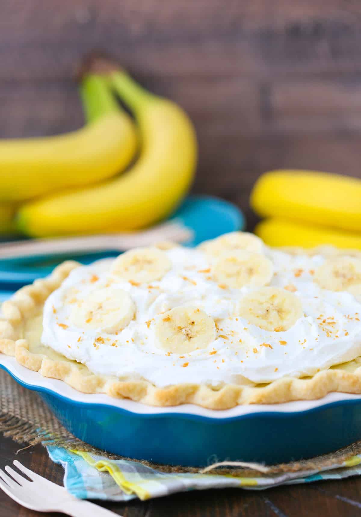 Side view of a banana cream pie in a blue pie pan.