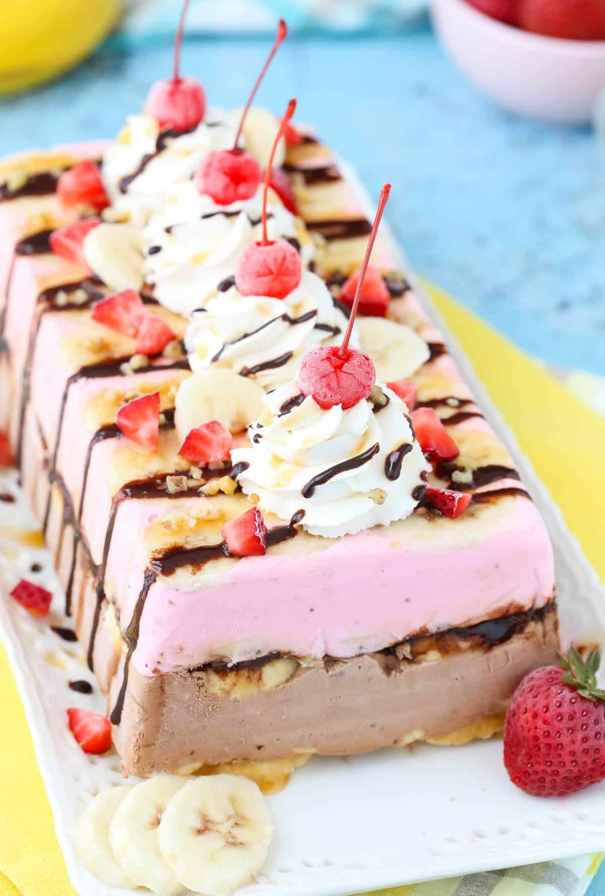 A banana split ice cream cake loaf on a white tray.