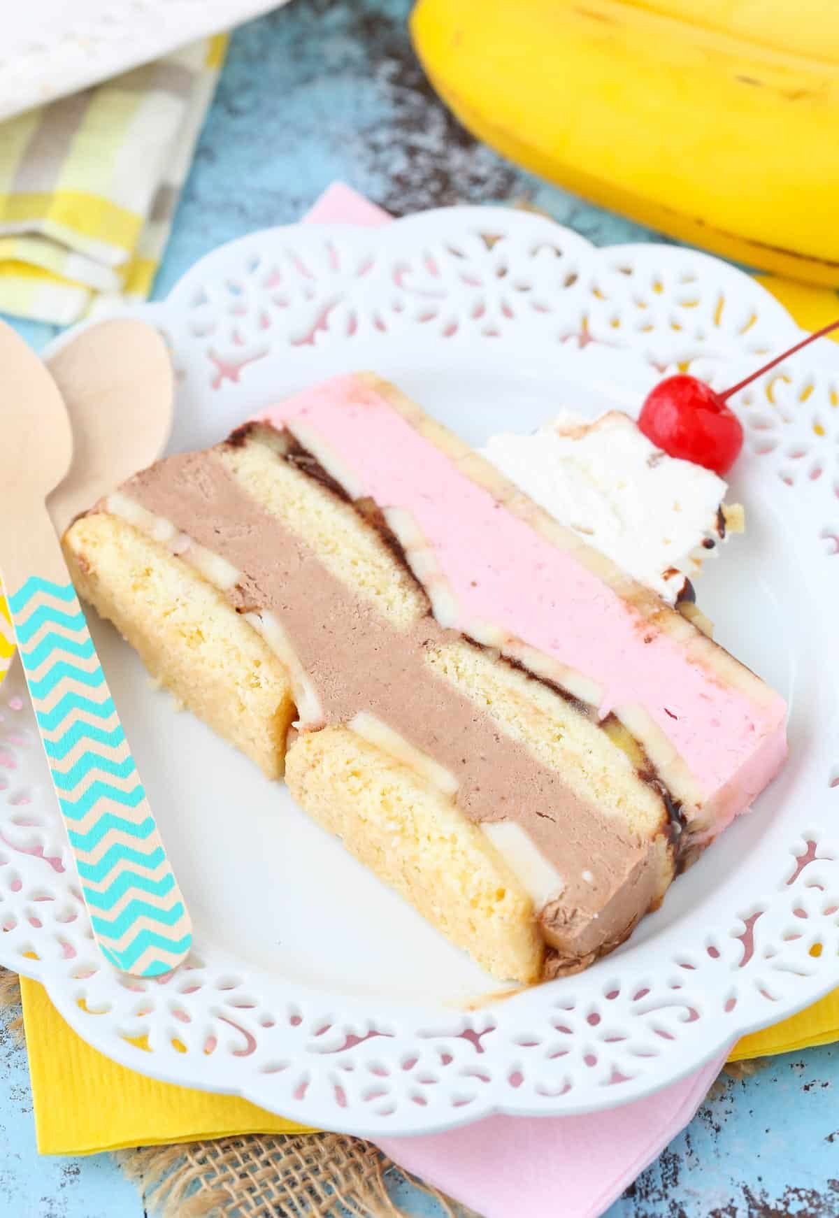 Close up of a slice of banana split ice cream cake loaf on a white plate.