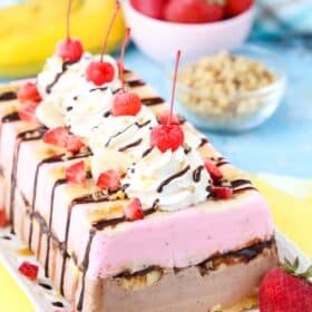 Side view of a banana split ice cream cake loaf on a white tray.