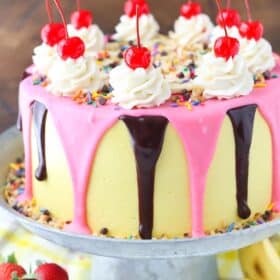 Close up of the side of a banana split layer cake on a silver cake stand.