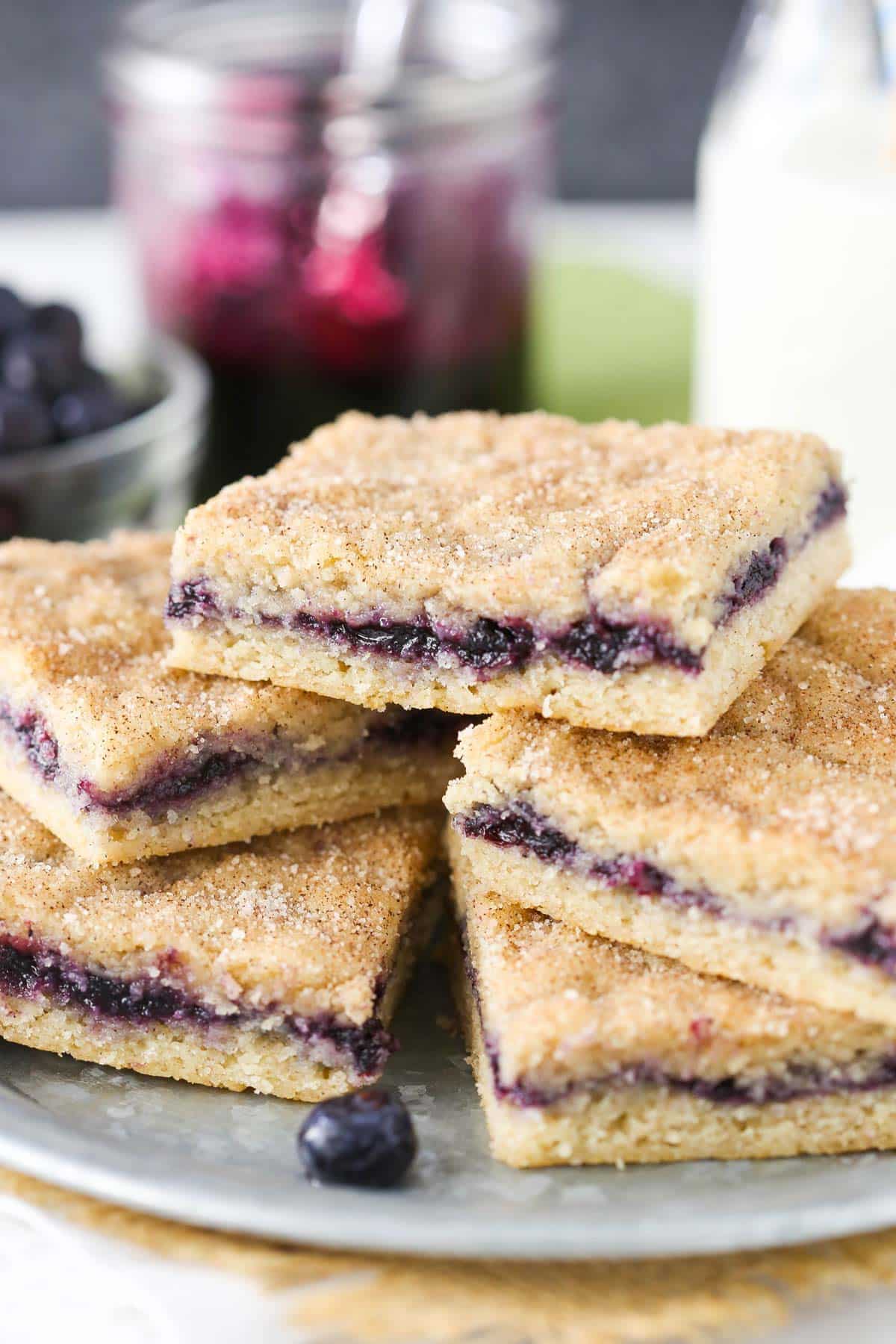 A silver plate piled with blueberry jam cake bars.