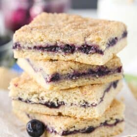Close up of a stack of 4 blueberry jam cake bars.