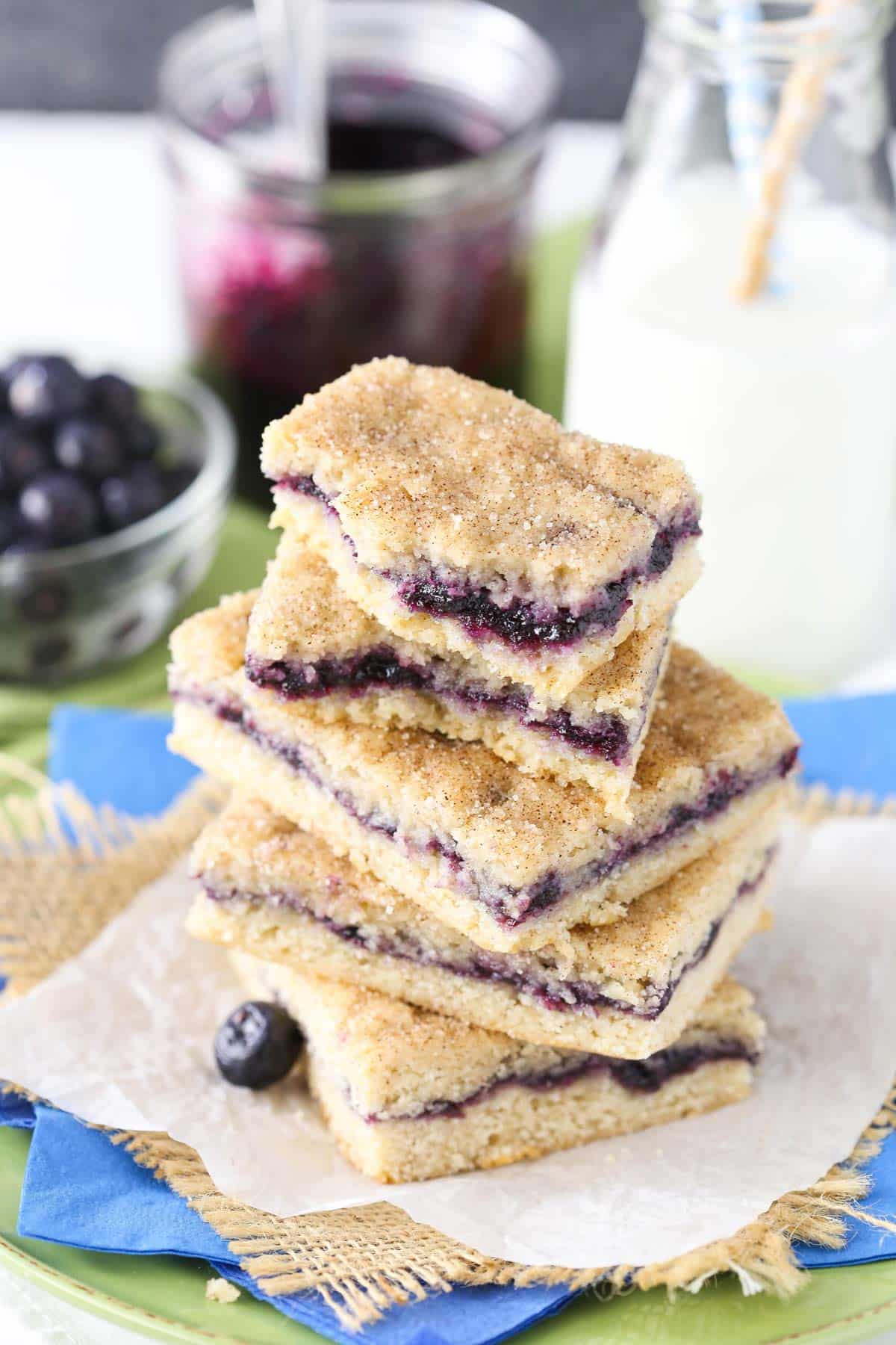 Top view of a stack of blueberry jam cake bars with the top bars broken to show filling.