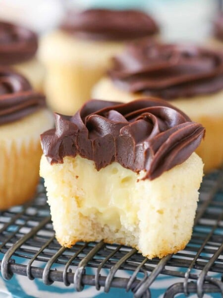 A Boston cream pie cupcake with a bite out of it to show center.