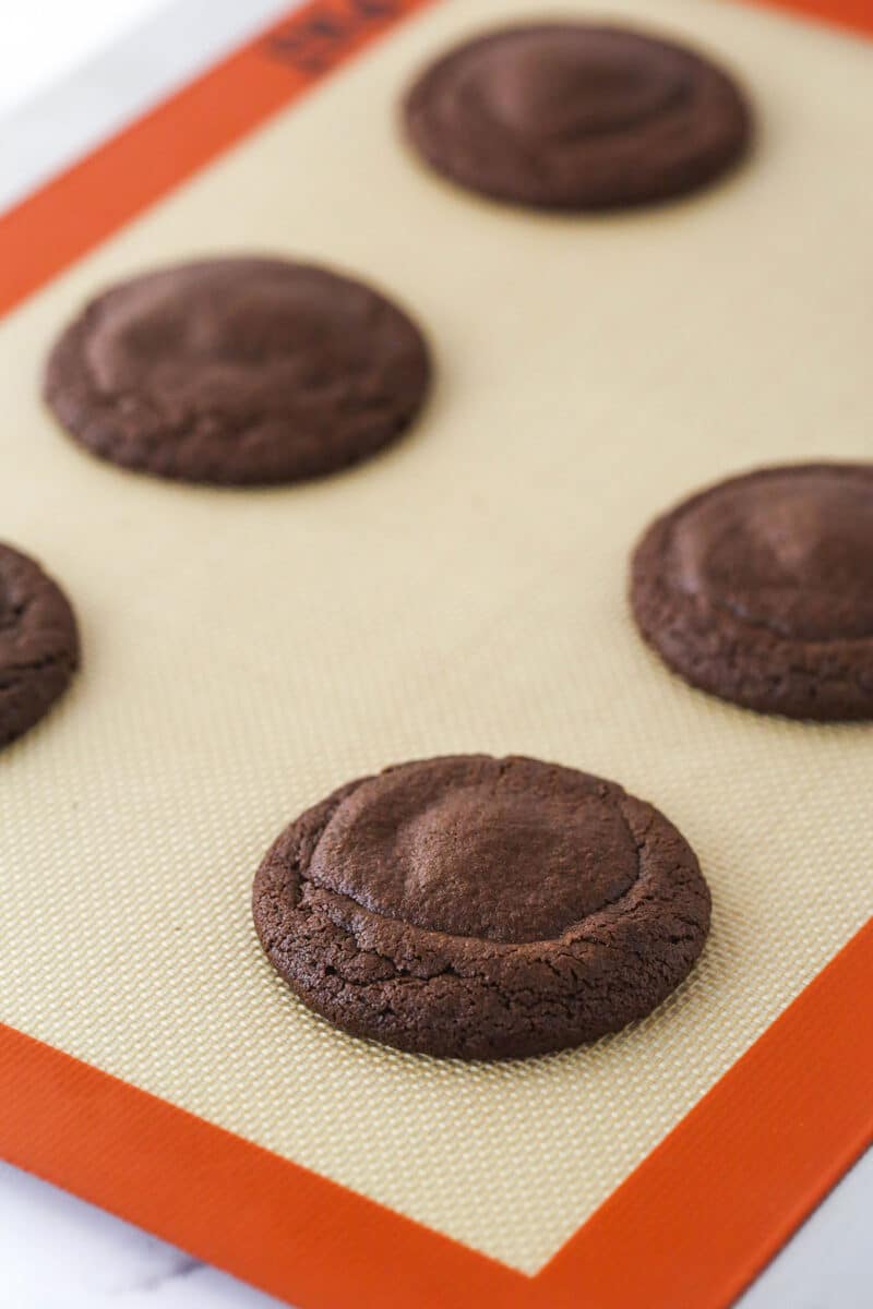 Caramel stuffed cookies on a baking sheet.