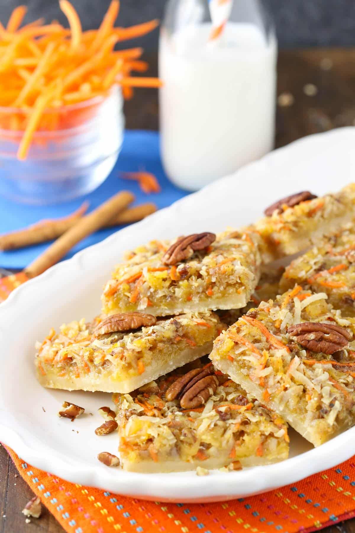 A pile of carrot cake shortbread bars on a white tray.
