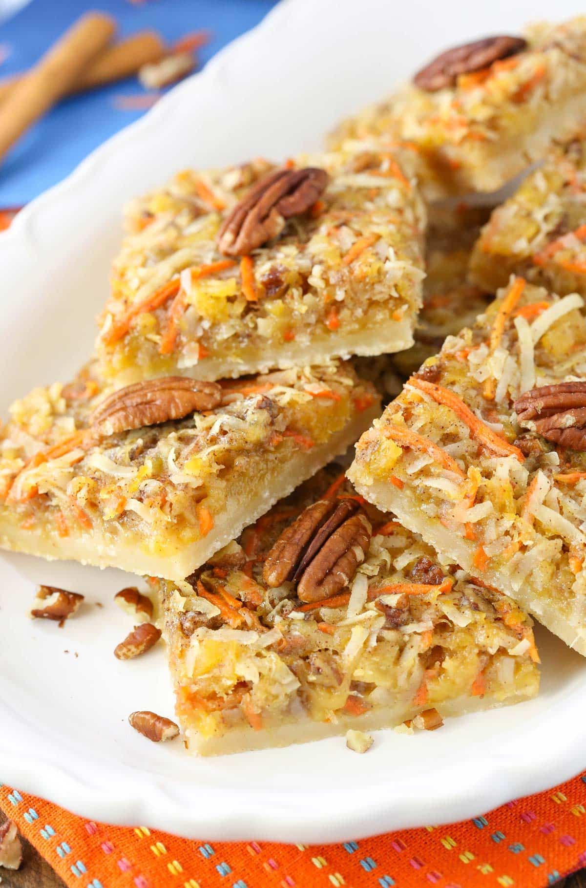 Top view of carrot cake shortbread bars piled on a white tray.