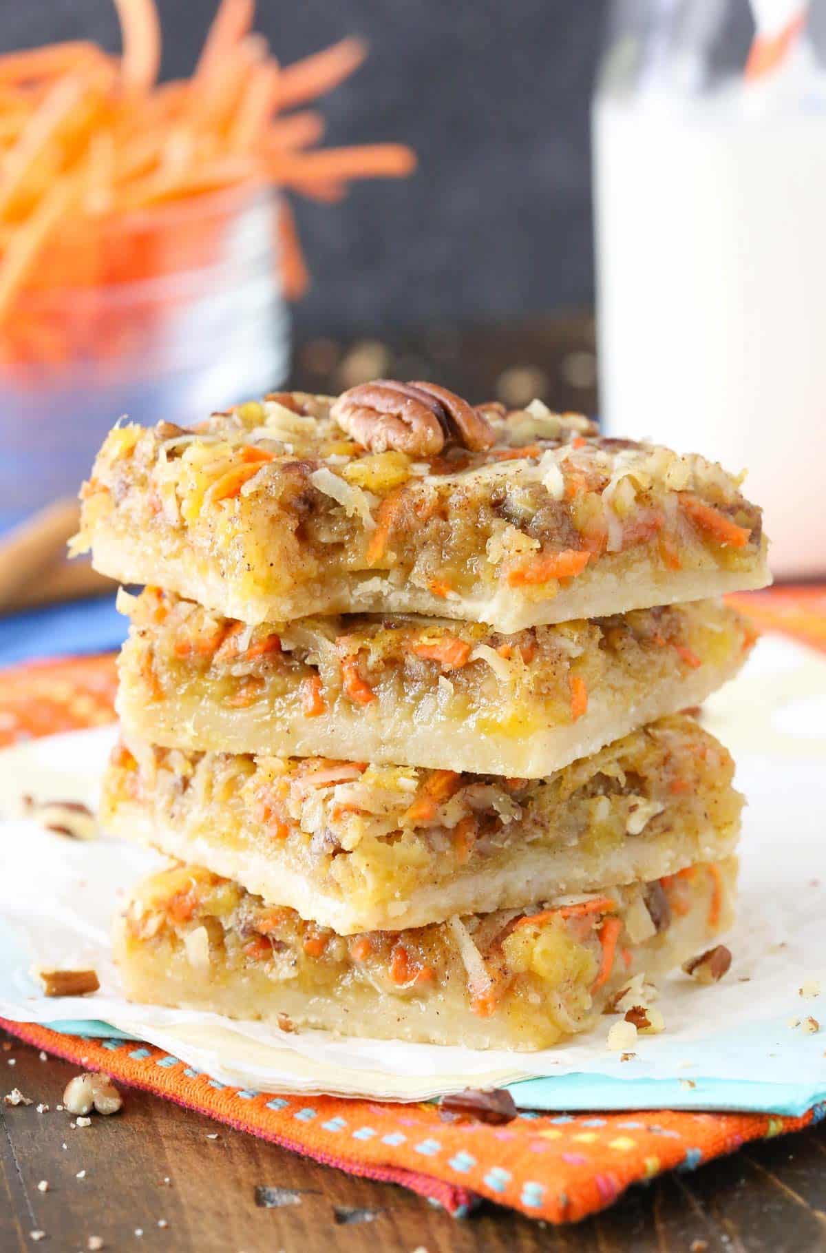 A stack of carrot cake shortbread bars with a bite taken out of the top bar.