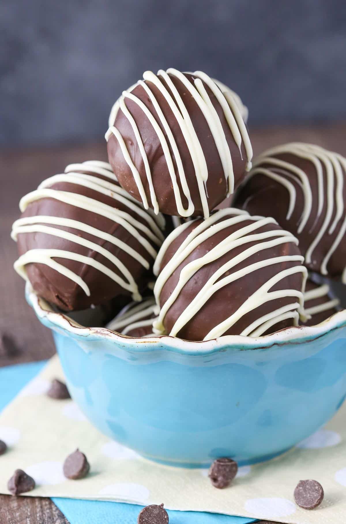 A light blue bowl filled with chocolate chip cookie dough cheesecake balls.