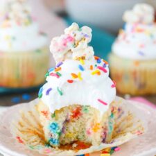 Close up of a funfetti popcorn marshmallow treat cupcake with a bite out of it.